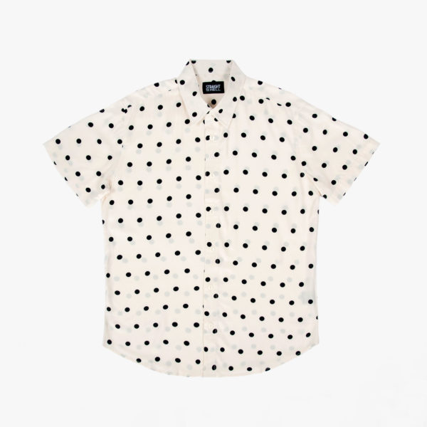 Short sleeve button up light cream shirt with black polka dots.
