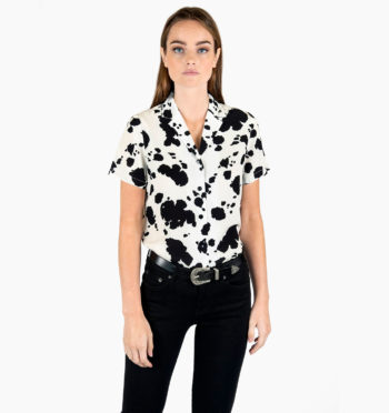 Short sleeve button up shirt with cow print and lapel collar.