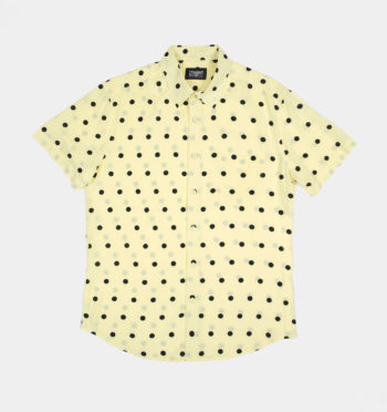 Short sleeve button up light yellow shirt with black polka dots.