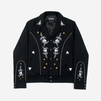 The Wilder is a black gabardine jacket with western details. It features white and metallic gold embroidery in a floral and star pattern.