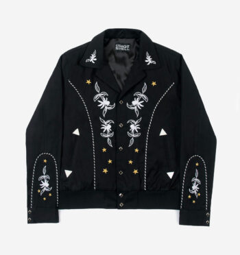The Wilder is a black gabardine jacket with western details. It features white and metallic gold embroidery in a floral and star pattern.
