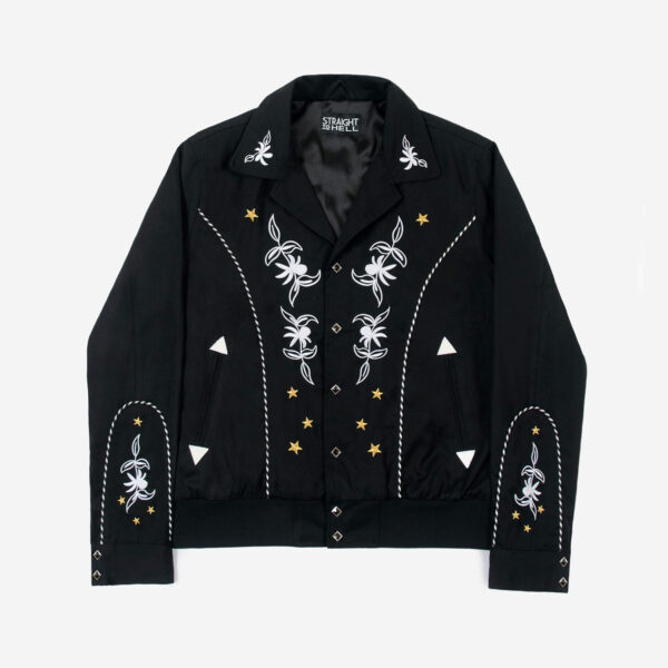 The Wilder is a black gabardine jacket with western details. It features white and metallic gold embroidery in a floral and star pattern.