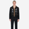 The Wilder is a black gabardine jacket with western details. It features white and metallic gold embroidery in a floral and star pattern.