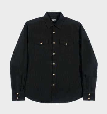 The Direct Action is a long-sleeve shirt made from durable twill with two chest pockets. The beige and brown snap closure stands out against the black fabric. This is our new True fit.