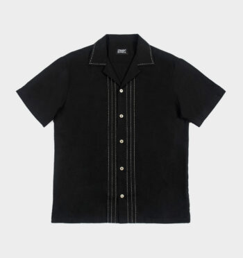 The Joliet is a short sleeve button up shirt with spread collar. White contrast stitching runs vertically along the button closure. The linen-viscose blend combines the airiness of linen and the softness of viscose.