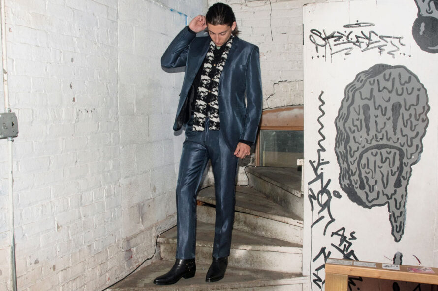 man wearing blue tonic suit on stairs