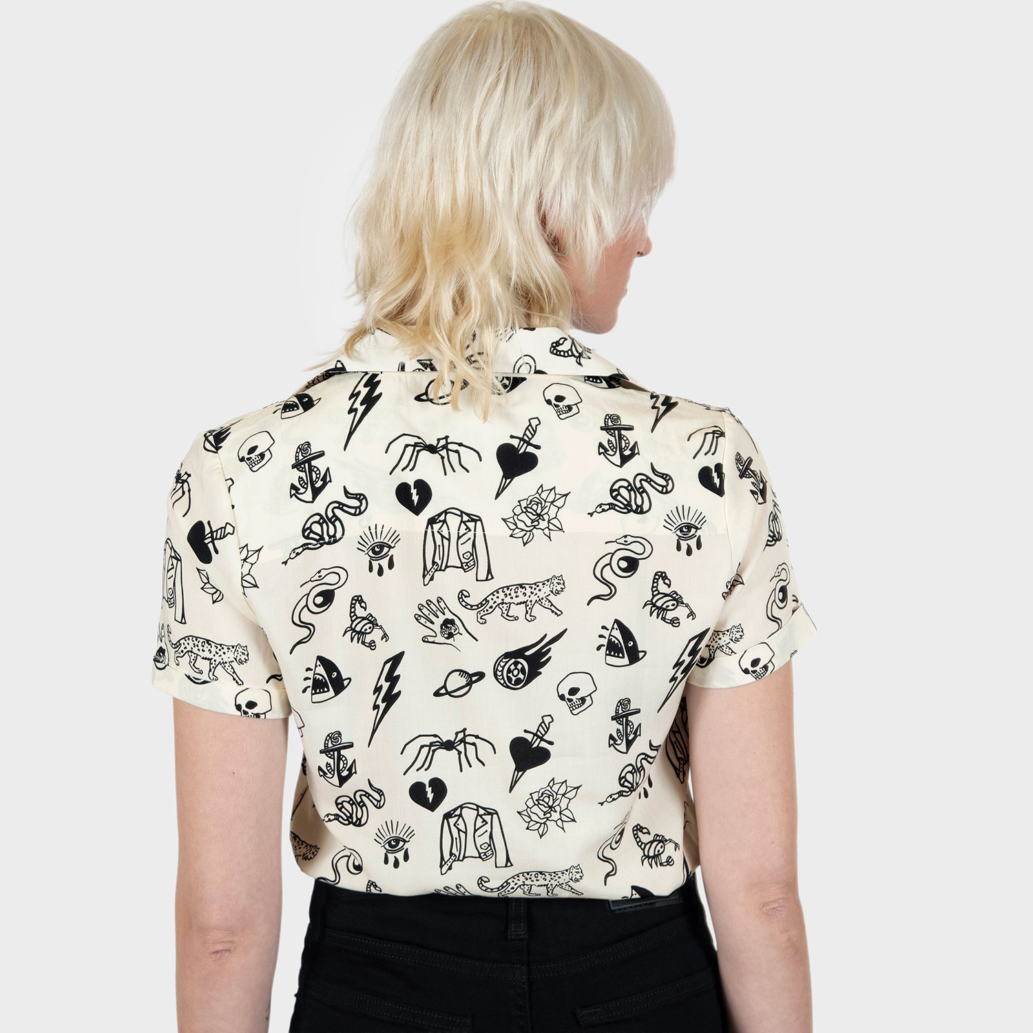 The Good Bad Not Evil shirt, filled with our doodle art. There are too many doodles to mention, but our favorites are snakes, dagger and hearts, roses, spiders, teardrop eyes, lightning bolts, cheetahs, and more. Soft cream fabric, a deep-V button up closure, dual chest pockets, and cuffed short sleeves.