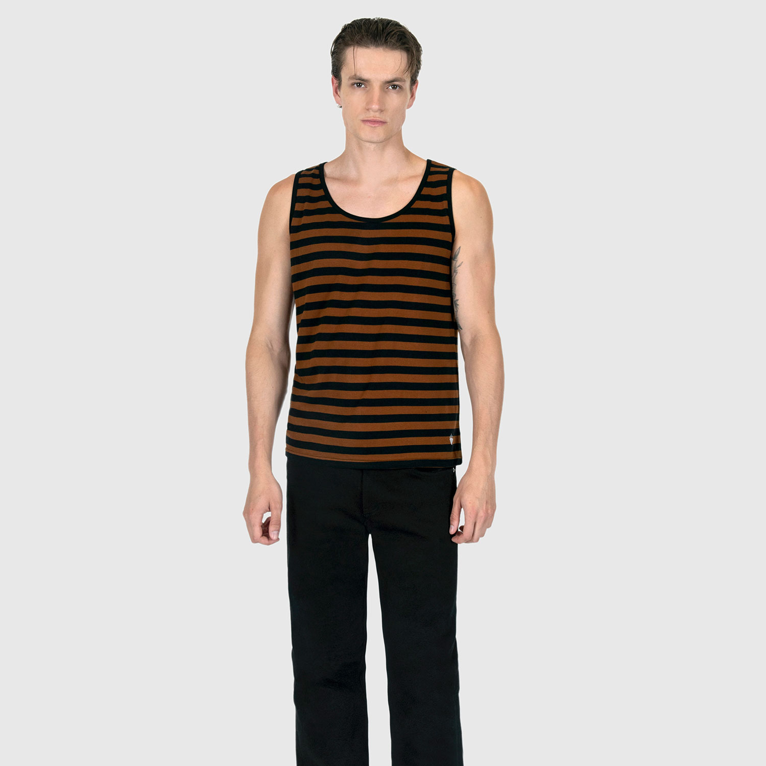 The Richie is a black and brown, short sleeve striped tank top. This soft cotton-poly blend allows the fabric to drape comfortably on your torso. It features a subtle diamond embroidered on the lower corner. This is our Bucktown fit.