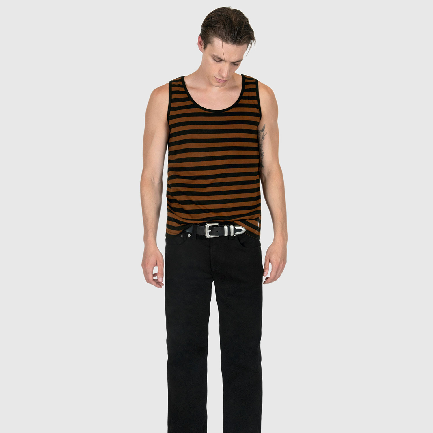 The Richie is a black and brown, short sleeve striped tank top. This soft cotton-poly blend allows the fabric to drape comfortably on your torso. It features a subtle diamond embroidered on the lower corner. This is our Bucktown fit.