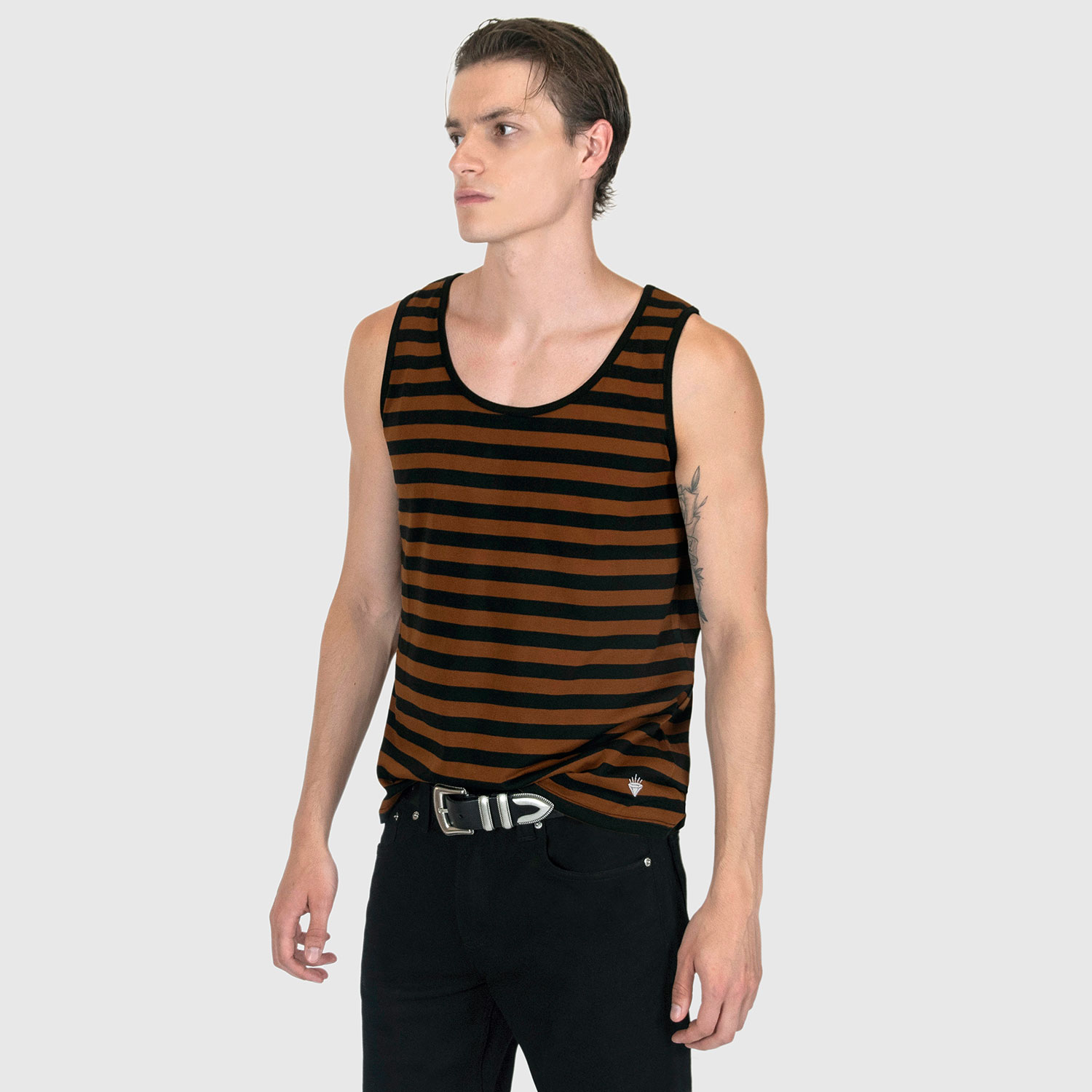The Richie is a black and brown, short sleeve striped tank top. This soft cotton-poly blend allows the fabric to drape comfortably on your torso. It features a subtle diamond embroidered on the lower corner. This is our Bucktown fit.