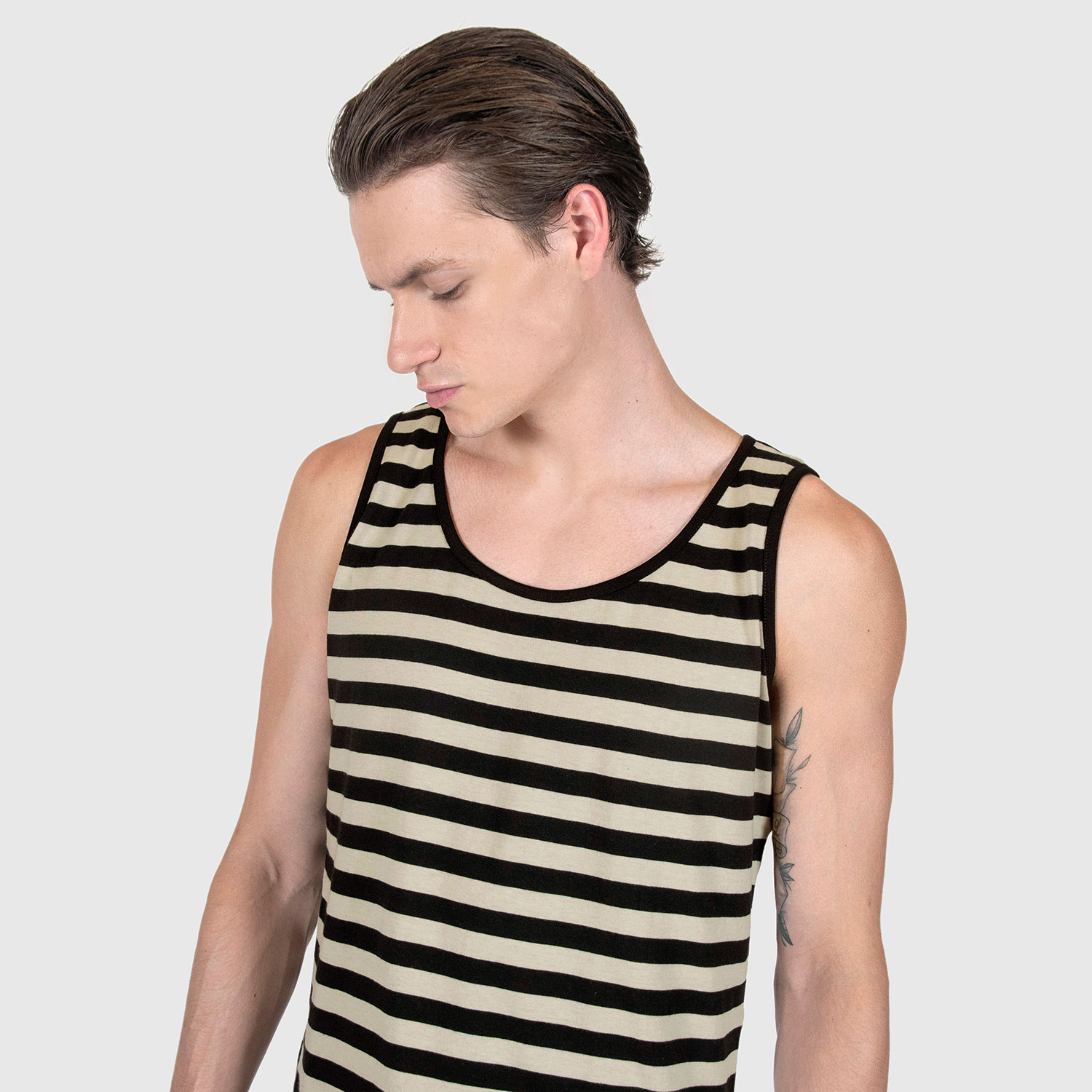 The Richie is a black and cream, short sleeve striped tank top. This soft cotton-poly blend allows the fabric to drape comfortably on your torso. It features a subtle diamond embroidered on the lower corner. This is our Bucktown fit.