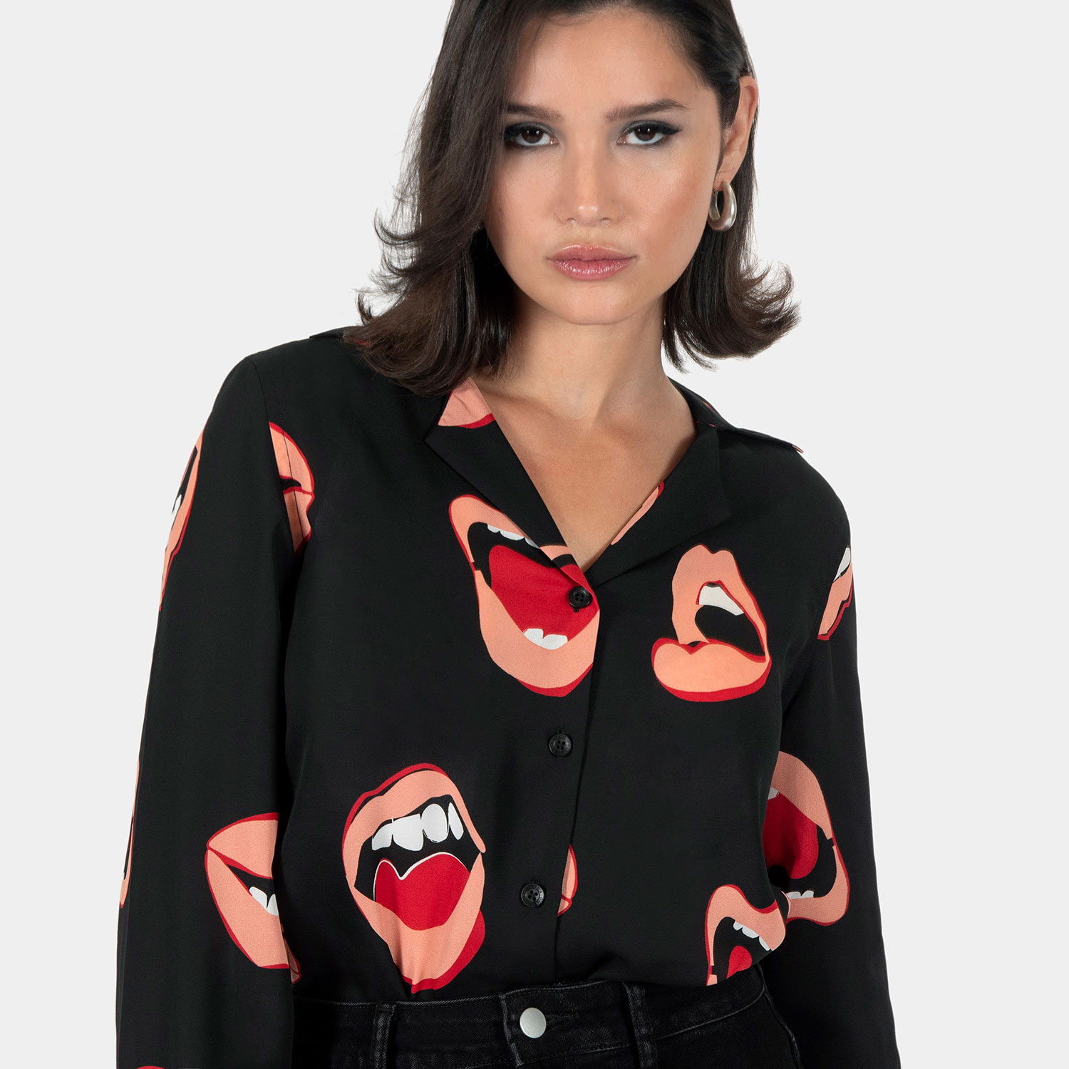 The Talk To Me long sleeve shirt, filled with retro open mouth artwork. Semi-sheer fabric meets a deep-V button-up closure and subtle balloon sleeves. This is our Casual fit.