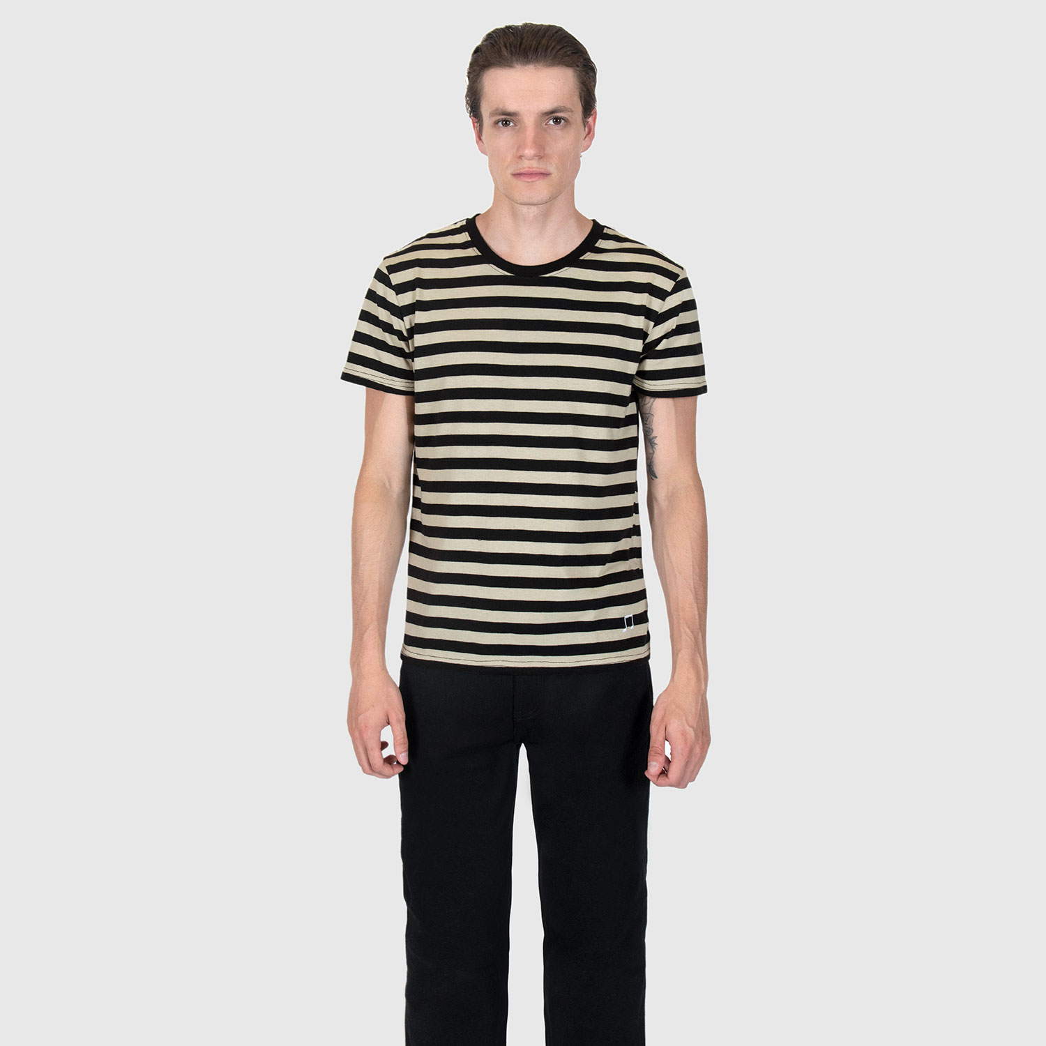 The Teddy is a black and cream, short sleeve striped t-shirt. This soft cotton-poly blend allows the fabric to drape comfortably on your torso. It features a subtle music note embroidered on the lower corner. This is our Bucktown fit.