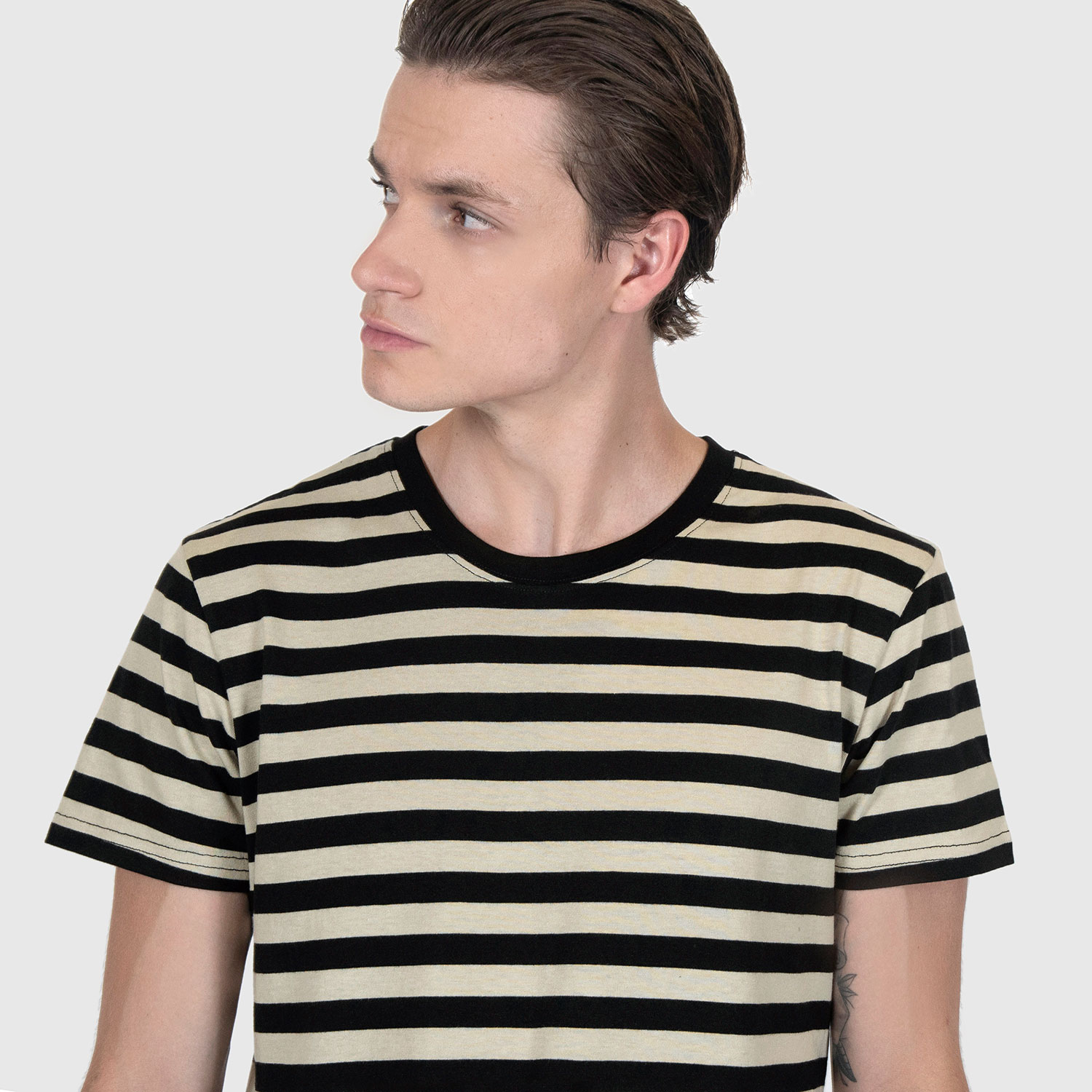 The Teddy is a black and cream, short sleeve striped t-shirt. This soft cotton-poly blend allows the fabric to drape comfortably on your torso. It features a subtle music note embroidered on the lower corner. This is our Bucktown fit.