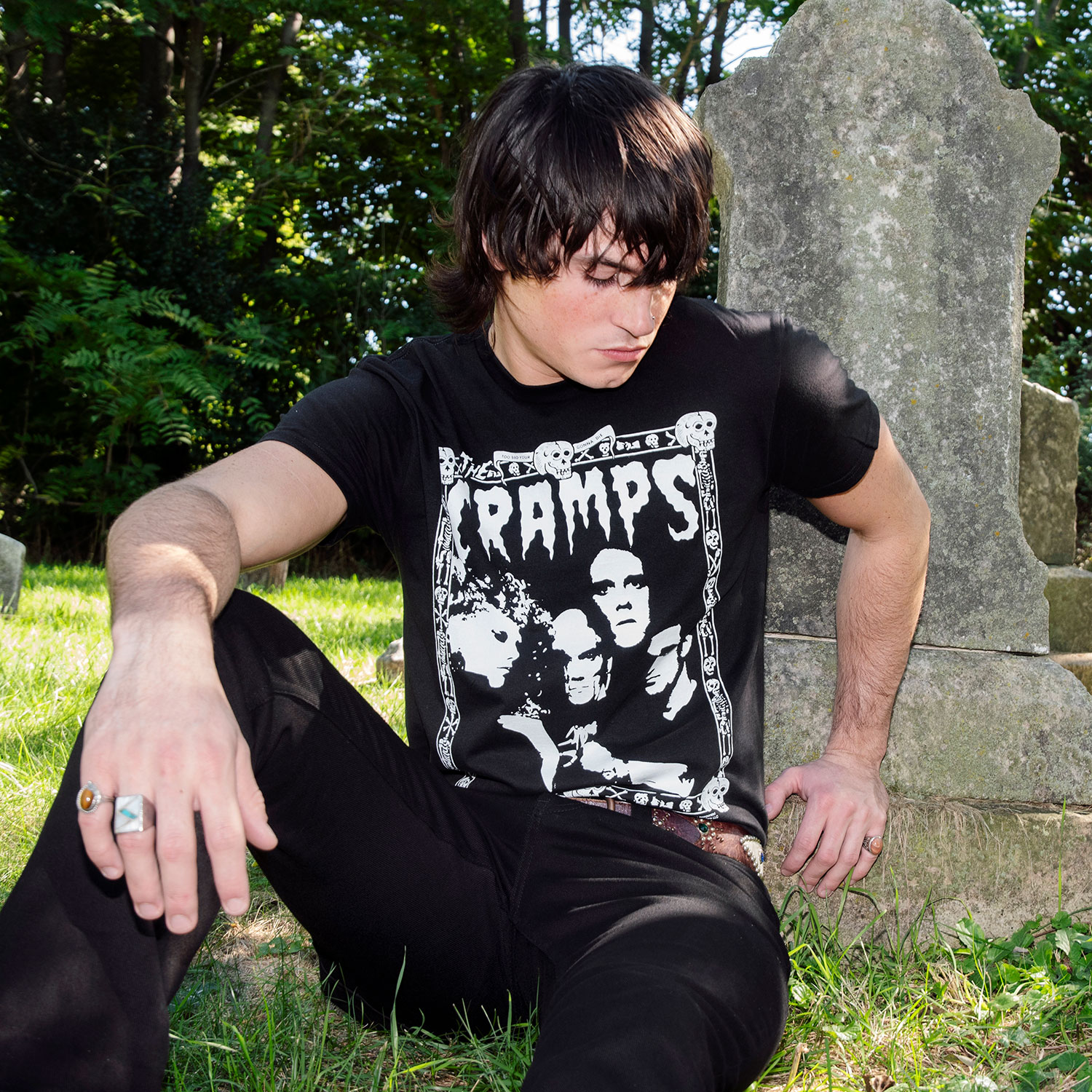 The Cramps official t-shirts are here for a limited time. Artwork from their debut album, Songs the Lord Taught Us, goes big inside the band’s classic skull-and-bones Too Bad You’re Gonna Die border. For The Cramps fan who appreciates more than the average band tee, this one delivers in black and white. Made from soft cotton and printed in-house in Chicago. This is our Everyday fit. Let’s talk about The Cramps and their shocking sound. Trashy, primitive punk and garage rock collide with raw R&B, fuzzed-out rockabilly gone wrong, B-movie sleaze, and ’50s rock ‘n’ roll dragged through the gutter. Do you get it now? Good.