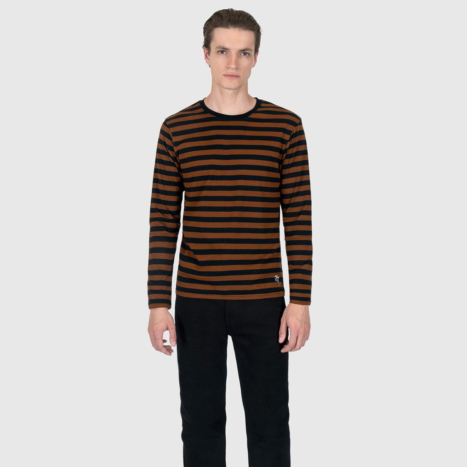 The Fitz 77 is a black and brown striped, long sleeve t-shirt. This soft cotton-poly blend allows the fabric to drape comfortably on your torso. It features a subtle 77 embroidered on the lower corner. This is our Bucktown fit.