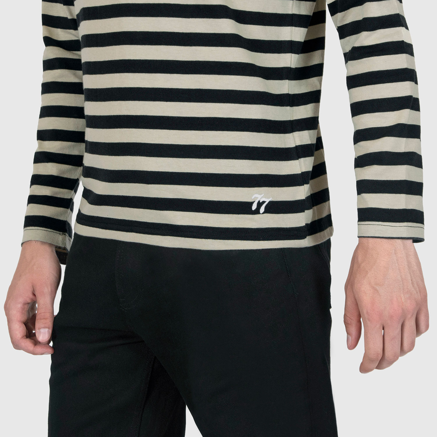 The Fitz 77 is a black and cream striped, long sleeve t-shirt. This soft cotton-poly blend allows the fabric to drape comfortably on your torso. It features a subtle 77 embroidered on the lower corner. This is our Bucktown fit.