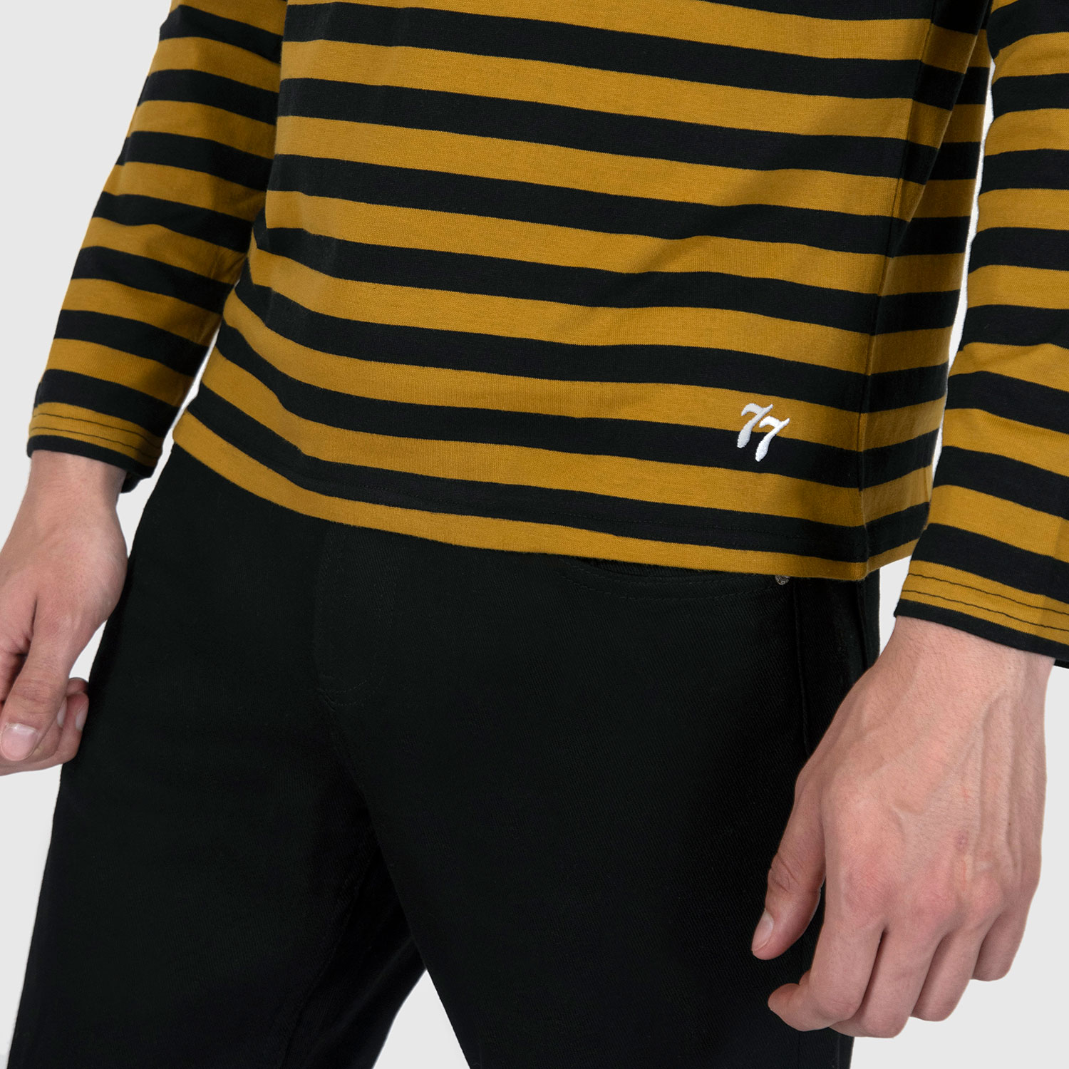 The Fitz 77 is a black and yellow striped, long sleeve t-shirt. This soft cotton-poly blend allows the fabric to drape comfortably on your torso. It features a subtle 77 embroidered on the lower corner. This is our Bucktown fit.