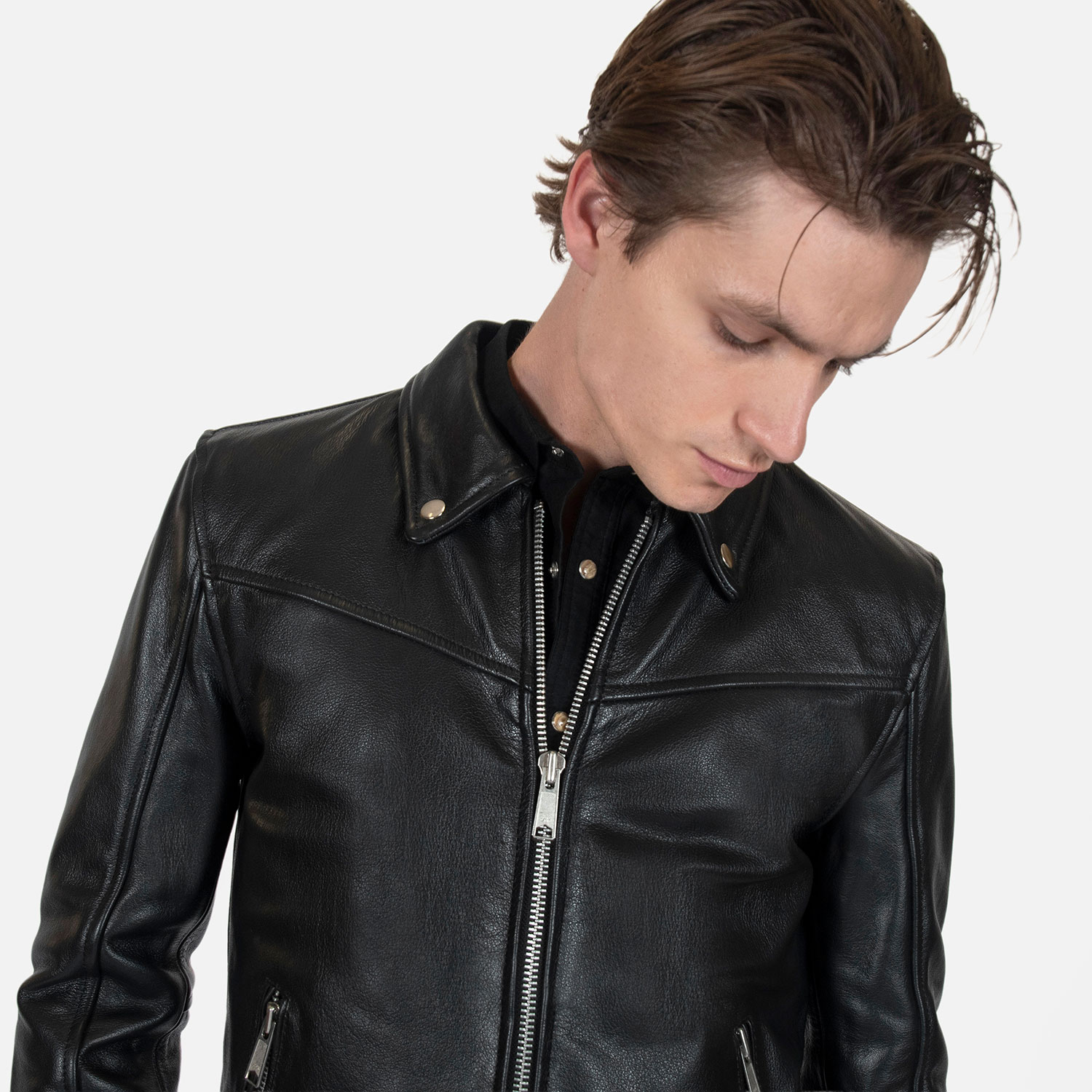 The Tribe leather jacket keeps things simple without sacrificing character. The diagonal chest seam detailing adds a subtle edge without complicating the design. A unique snap belt gives this classic style its own identity. Featuring a snap collar, vertical zipper closure, side pockets, and our Modern fit. All the attitude of a classic moto jacket, with a clean look that works just about anywhere. Made from premium leather that softens, relaxes, and conforms to your shape with wear, only getting better over time.